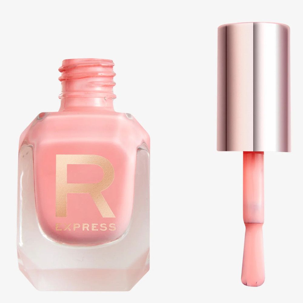Ein hellrosa Nagellack in einem sechseckigen Glasfläschchen mit einem goldenen 'R'-Logo. Der Pinsel ist herausgezogen und zeigt die Farbe.