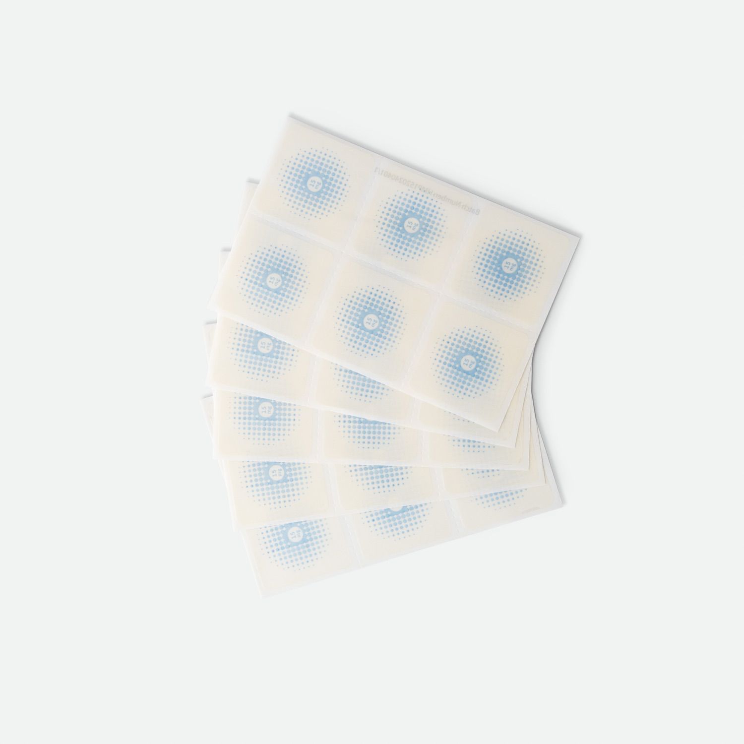 Mehrere quadratische Pflaster mit blauem Punktmuster. Auf weißem Hintergrund angeordnet.