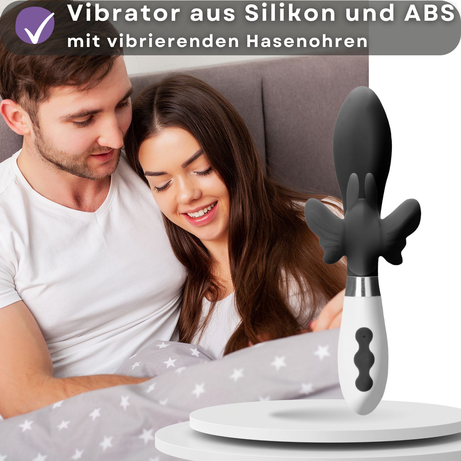Schwarzer Vibrator mit Hasenohren. Weißer Griff. Paar im Bett im Hintergrund.