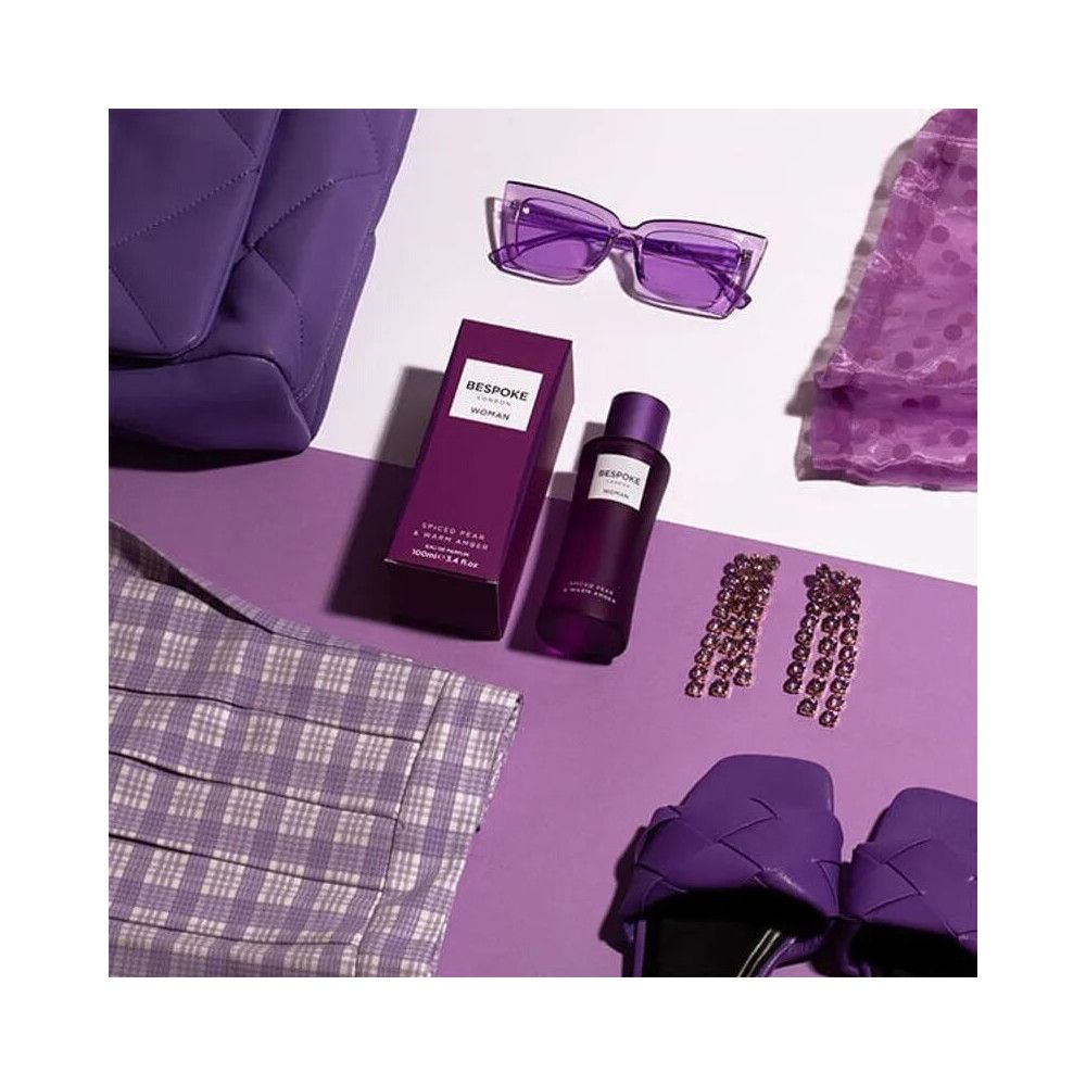 Violette Flasche und Schachtel. Umgeben von Accessoires: Sonnenbrille, Ohrringe, Tasche, Schuhe.
