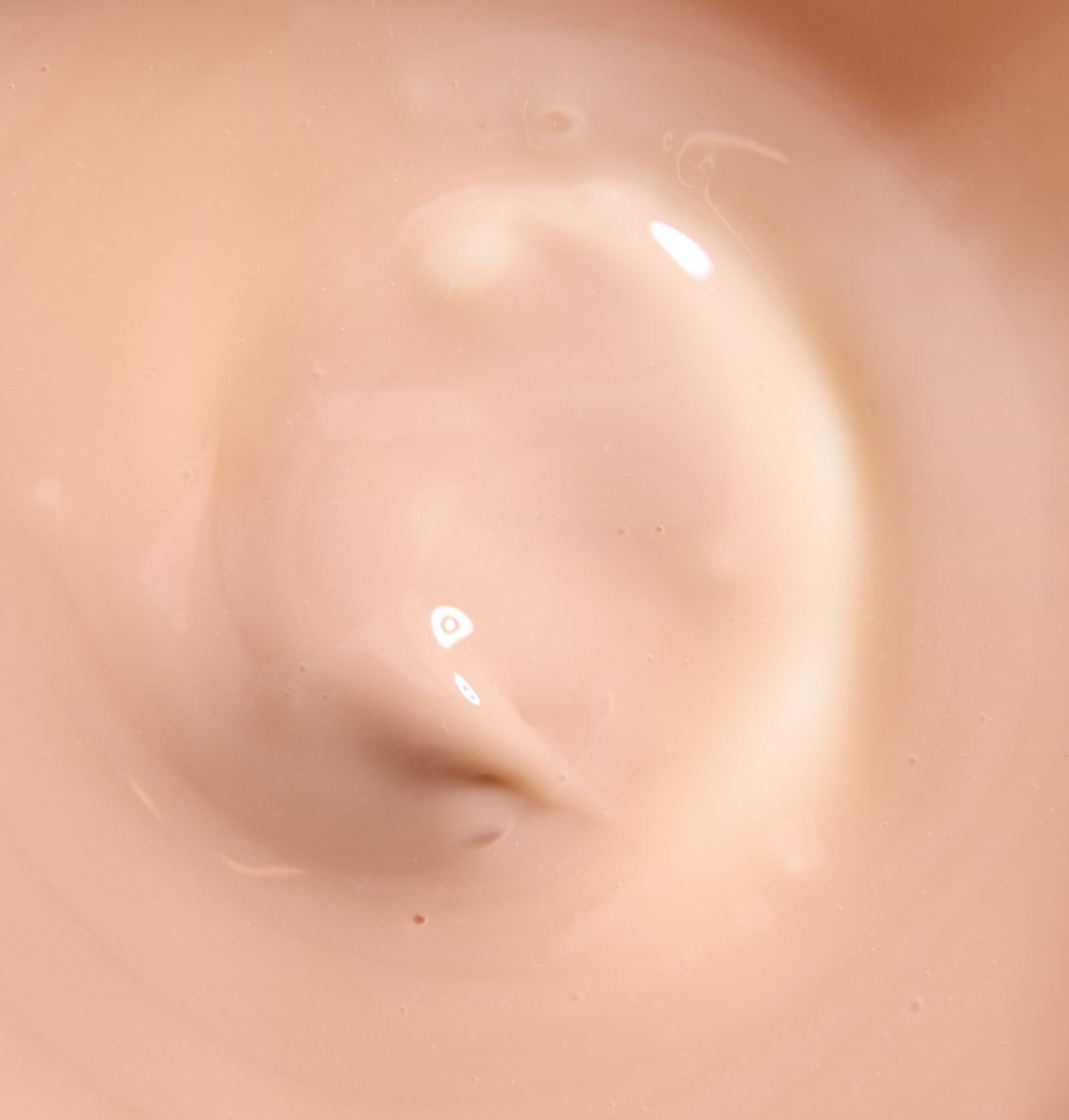 Nahaufnahme einer cremefarbenen, glänzenden Substanz. Die Textur ist glatt und cremig.