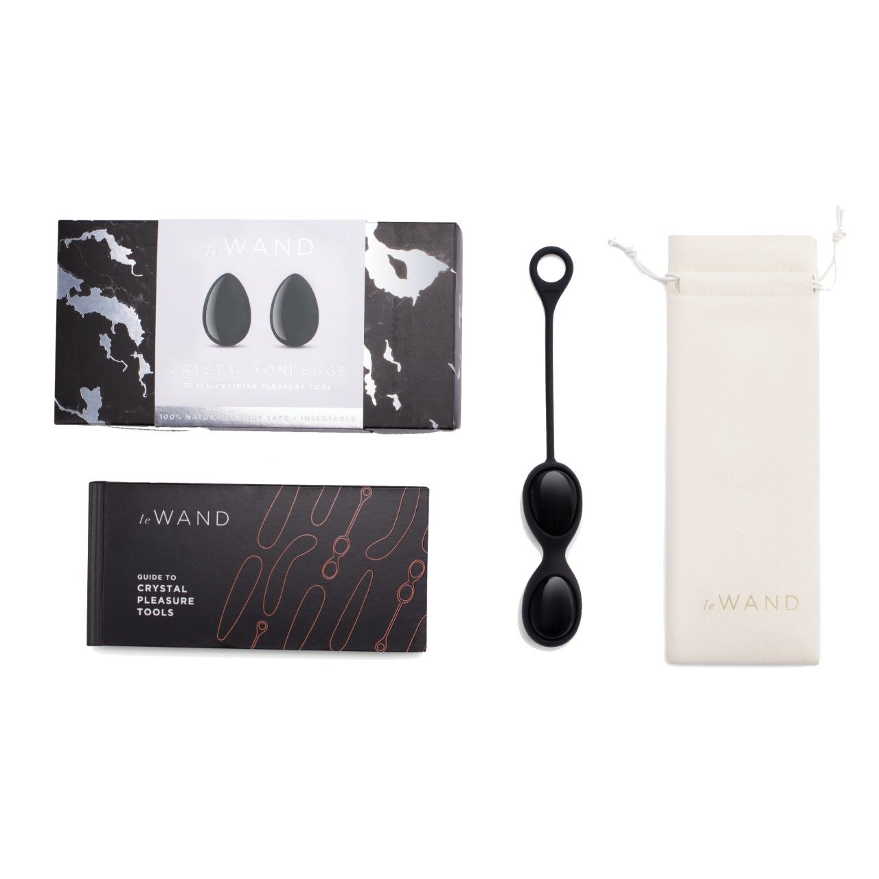 Set mit Crystal Yoni Eggs, Buch und Beutel. Schwarze Eier, Buch mit roter Schrift, Beutel mit Logo.
