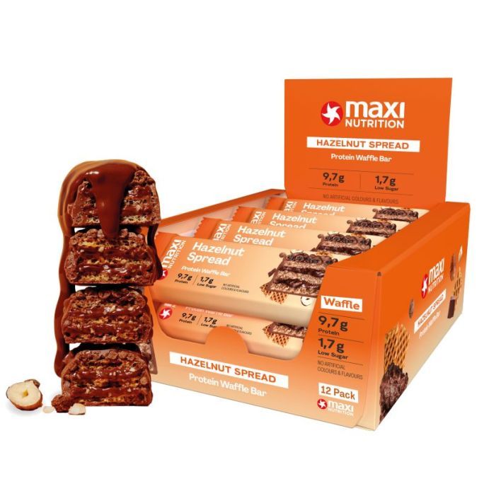Orangefarbene Verpackung mit Protein Waffle Bars. Aufschrift: MaxiNutrition, Hazelnut Spread, 12er Pack. Einige Riegel sind sichtbar.