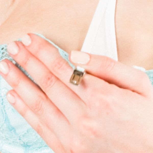 Nahaufnahme einer Hand, die einen hellblauen BH berührt. Der BH hat Spitze. Ring am Finger.