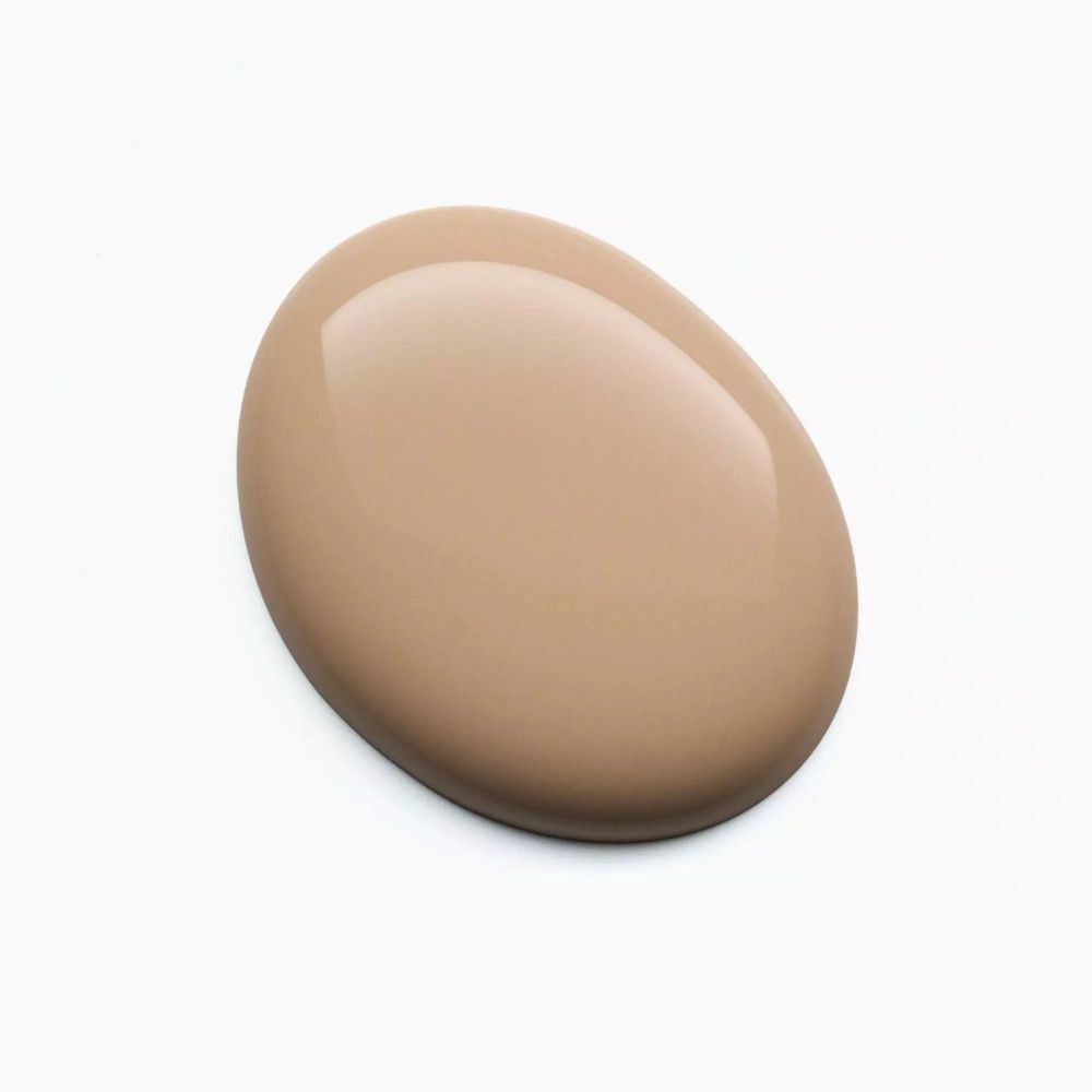 Beigefarbener Nagellacktropfen auf weißem Hintergrund. Glänzende Oberfläche.