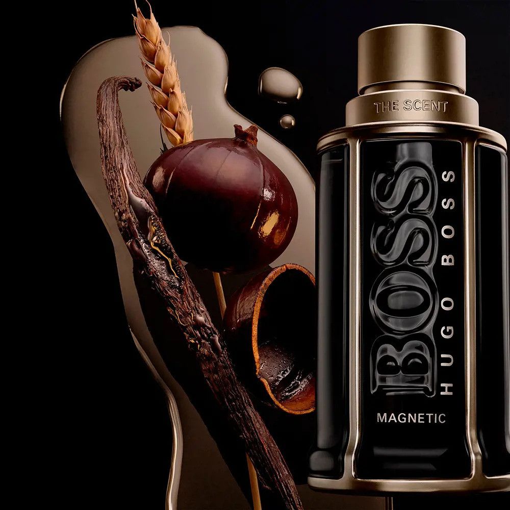 Schwarzer Flakon mit silbernem Deckel, umgeben von Zutaten. "BOSS" und "MAGNETIC" sind sichtbar. "HUGO BOSS" und "THE SCENT" sind ebenfalls zu sehen.
