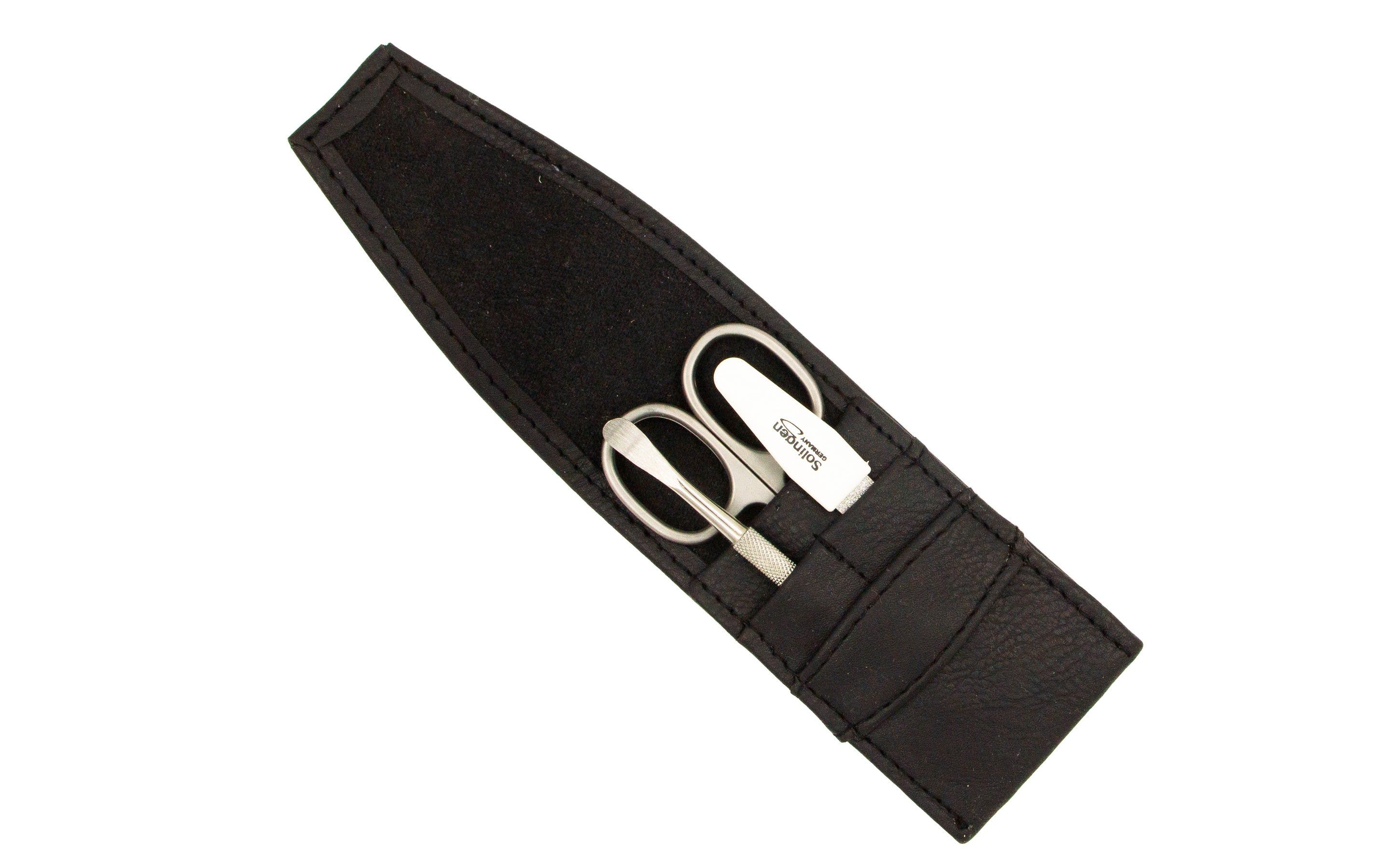 Schwarzes Kunstleder-Reiseetui mit Schere und Nagelfeile. Innenfutter. Auf weißem Hintergrund.