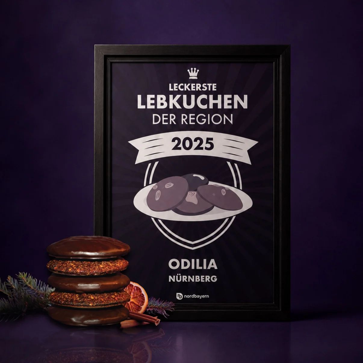 Gerahmte Urkunde "Leckerste Lebkuchen der Region 2025" mit Odilia Nürnberg und Lebkuchen.