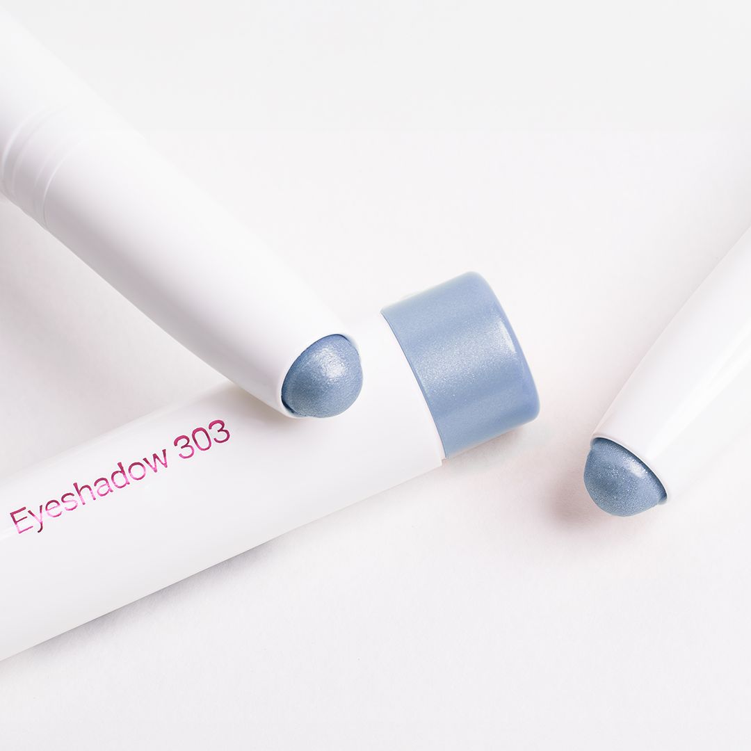Drei weiße Lidschattenstifte mit blauem Ende. Aufschrift "Eyeshadow 303".