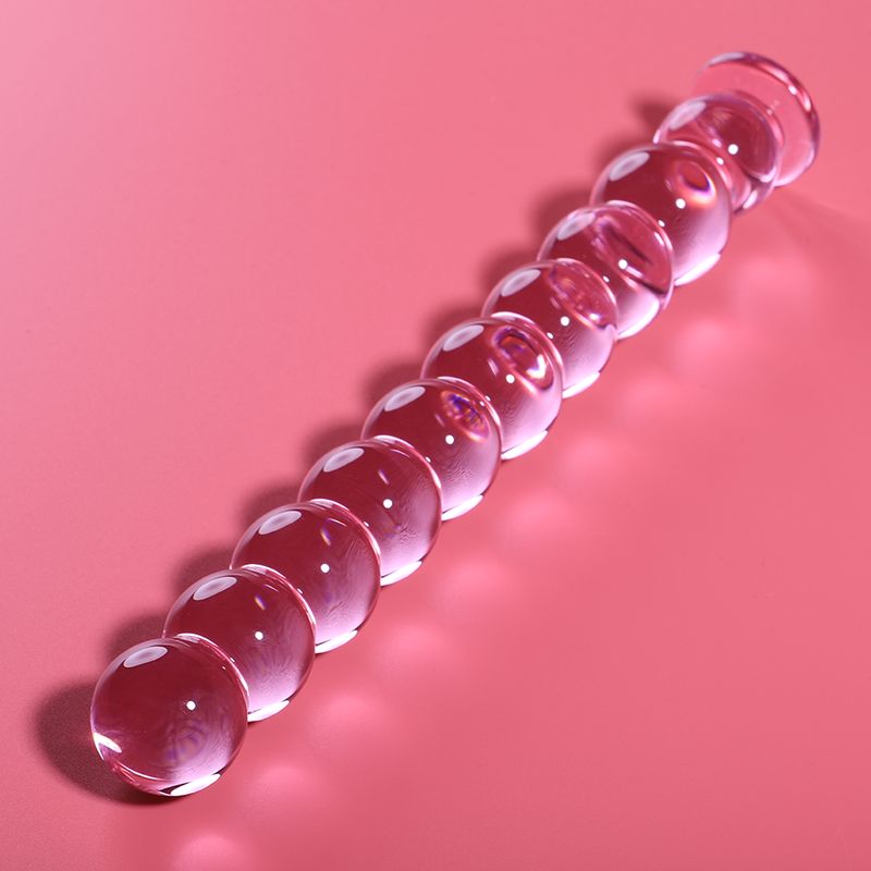 Rosa Dildo aus Borosilikatglas mit 10 Kugeln. Auf rosa Hintergrund.
