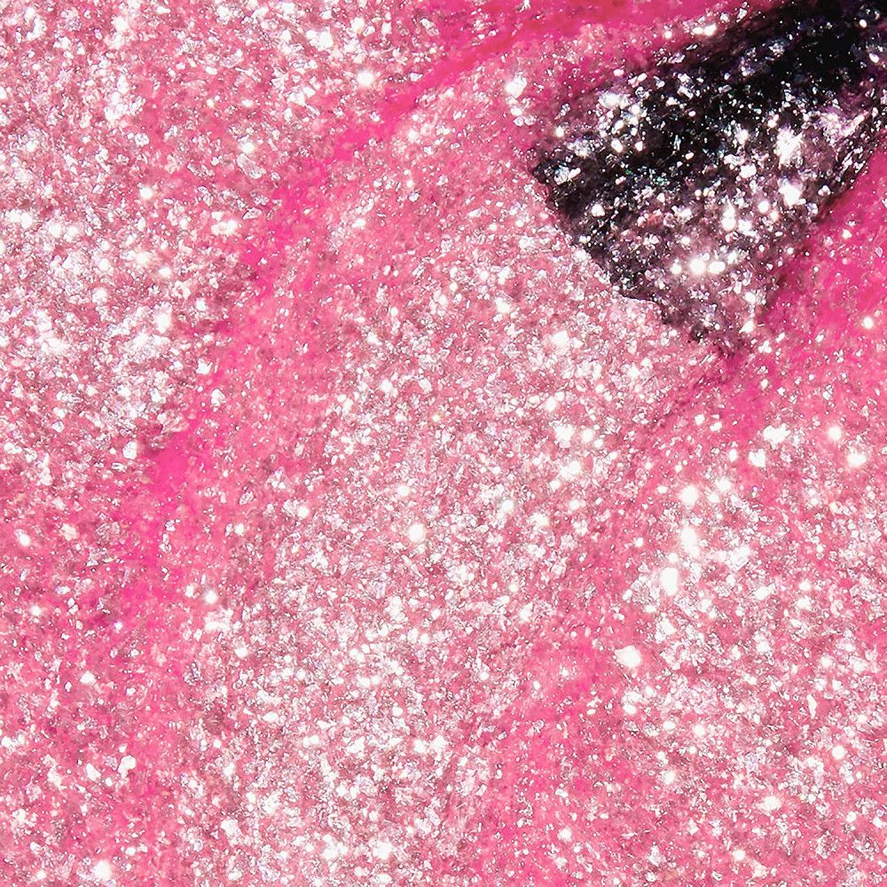 Rosa Nagellack mit Glitzer. Der Pinsel ist teilweise sichtbar.
