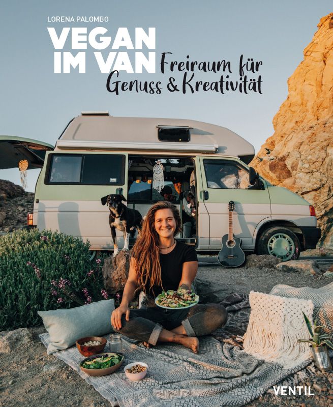 Buchcover mit Titel "VEGAN IM VAN". Frau sitzt vor Van, hält Teller mit Essen. Gitarre, Hund, Kissen und Decke liegen daneben.