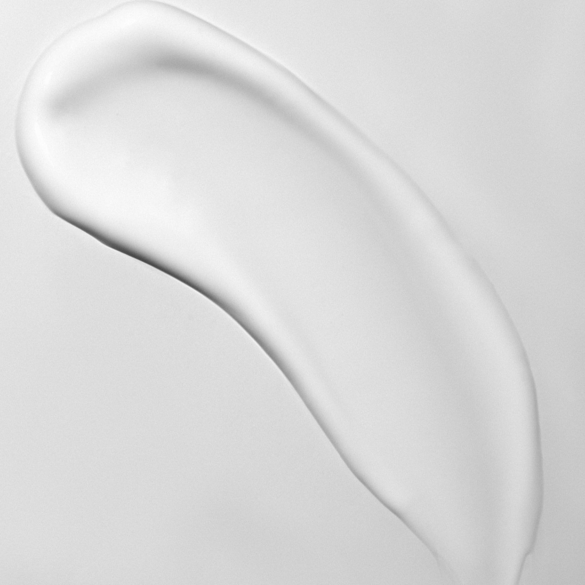 Eine weiße Creme-Spur auf grauem Hintergrund.