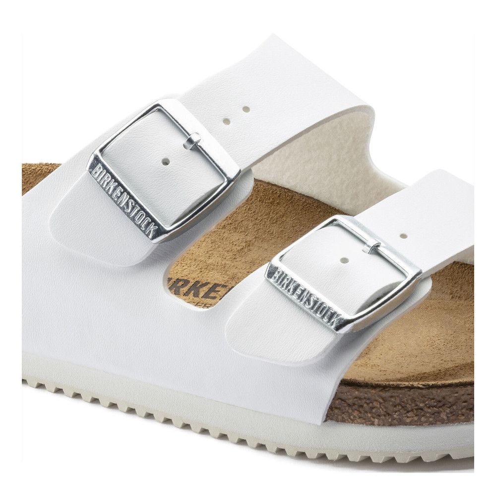 Nahaufnahme der Schnallen einer weißen Sandale. Birkenstock-Logo auf den Schnallen.