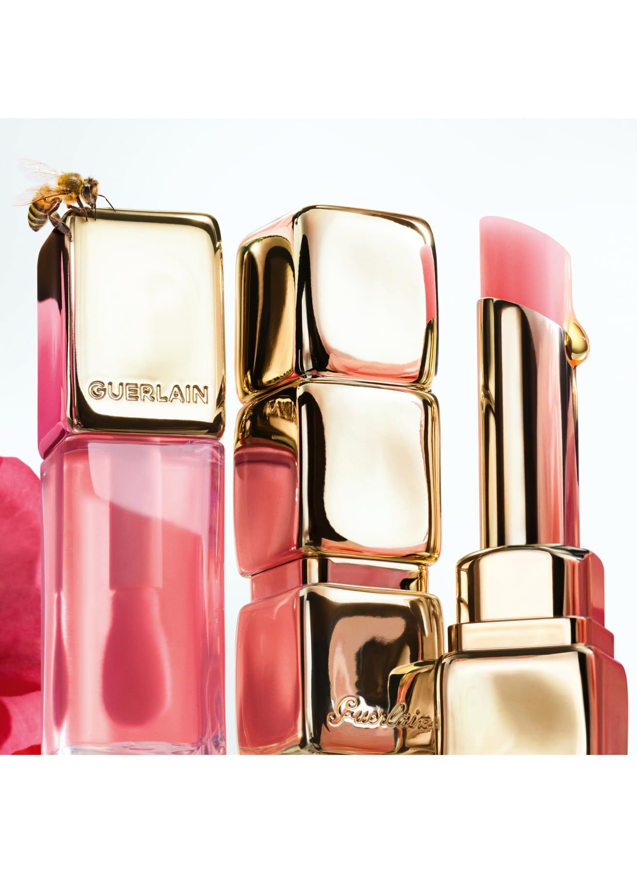 Mehrere Lippenbalsam-Verpackungen in Gold und Rosa, mit einer Biene auf einer Verpackung.