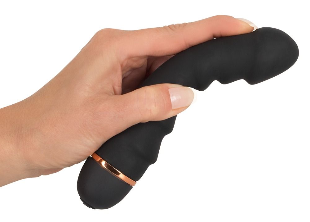 Schwarzer Vibrator, in einer Hand gehalten. Mit goldfarbenem Ring am unteren Ende. Geformt für vaginale oder anale Stimulation.