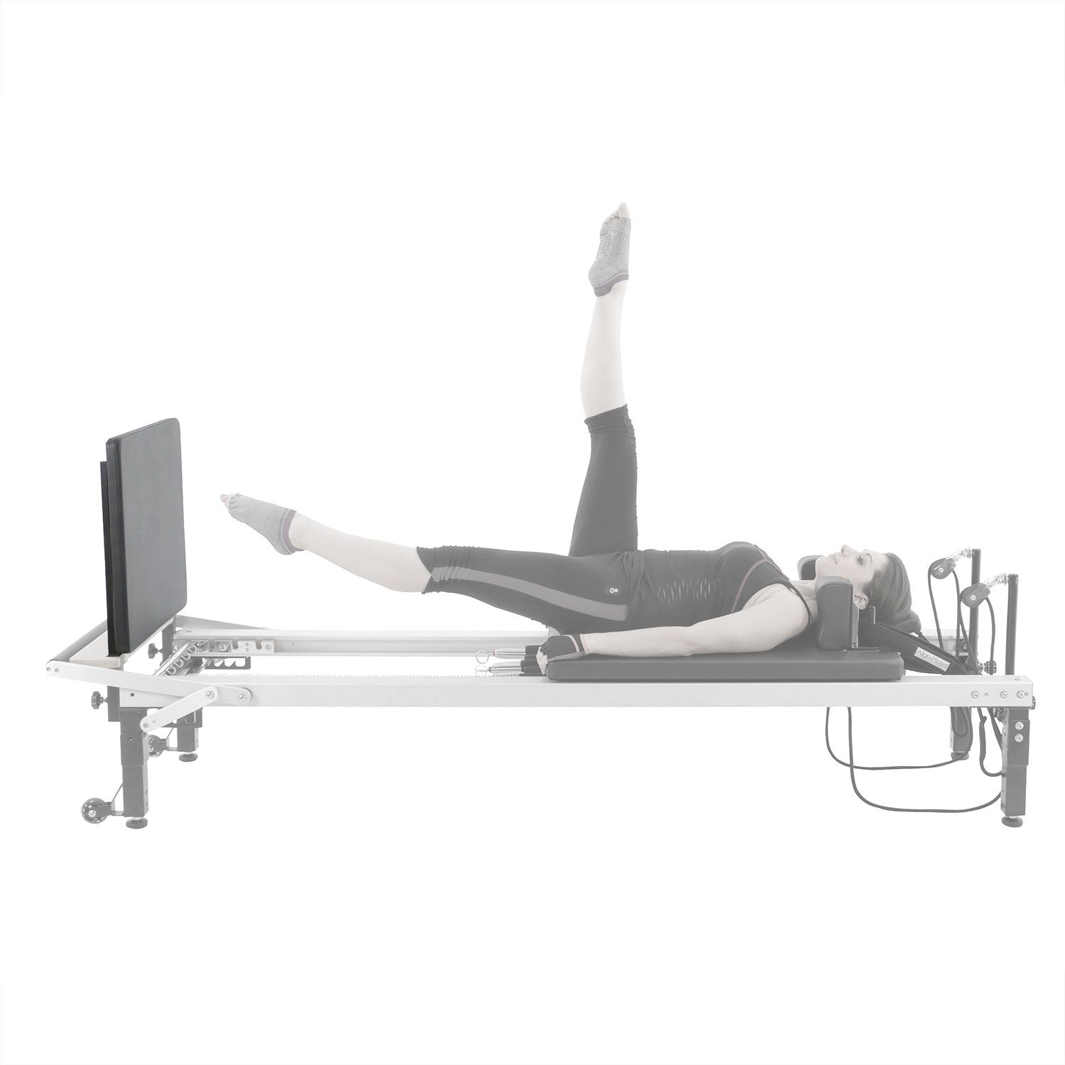 Pilates C2 Reformer Jumpboard. Person trainiert. Schwarze Polsterung, Metallrahmen. Seitenansicht.