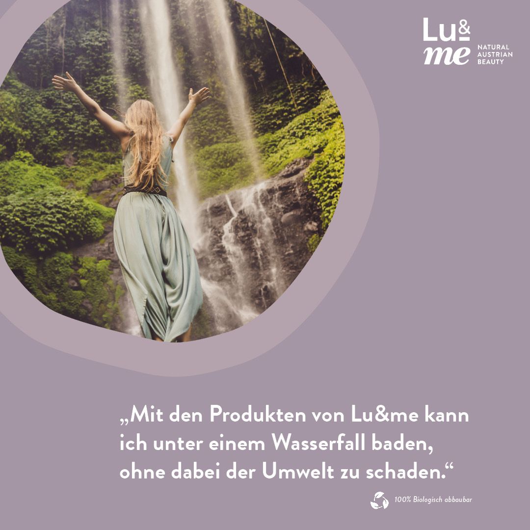 Frau mit offenen Armen vor einem Wasserfall. Text: Mit den Produkten von Lu&me kann ich unter einem Wasserfall baden.