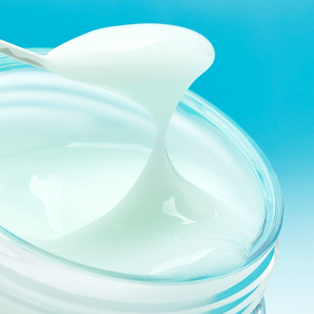 Eine Spatel hebt Numbuzin Pantothenic B5 Creme aus einem Glasbehälter.