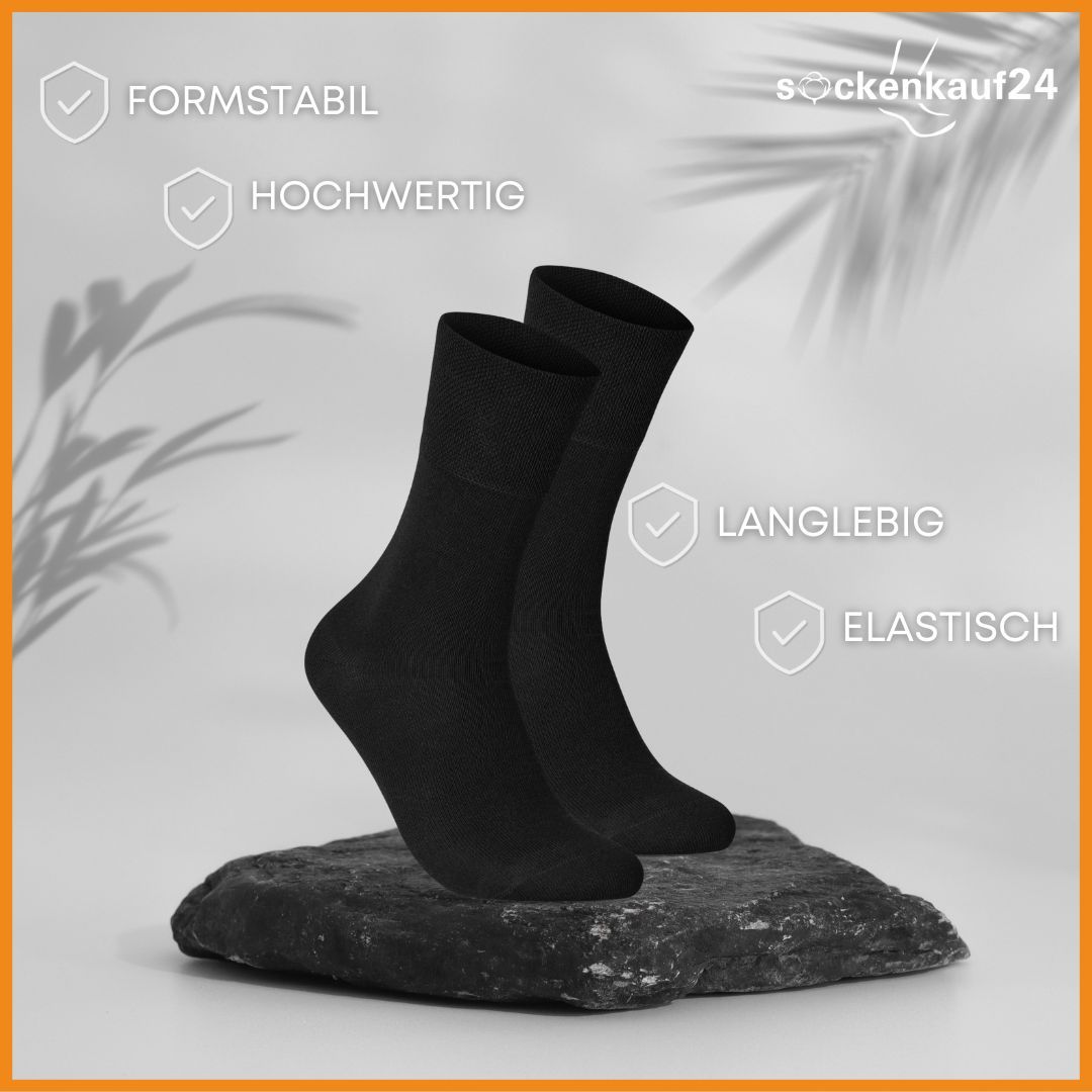 Zwei schwarze Socken auf einem Stein. Formstabil, hochwertig, langlebig und elastisch.