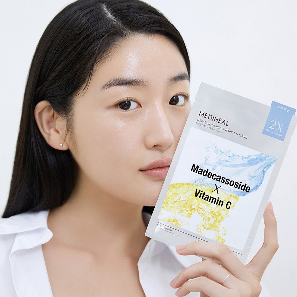 Frau hält Verpackung mit Gesichtsmaske. Aufschrift: Madecassoside X Vitamin C. Marke: MEDIHEAL Derma Synergy Wrapping Mask.