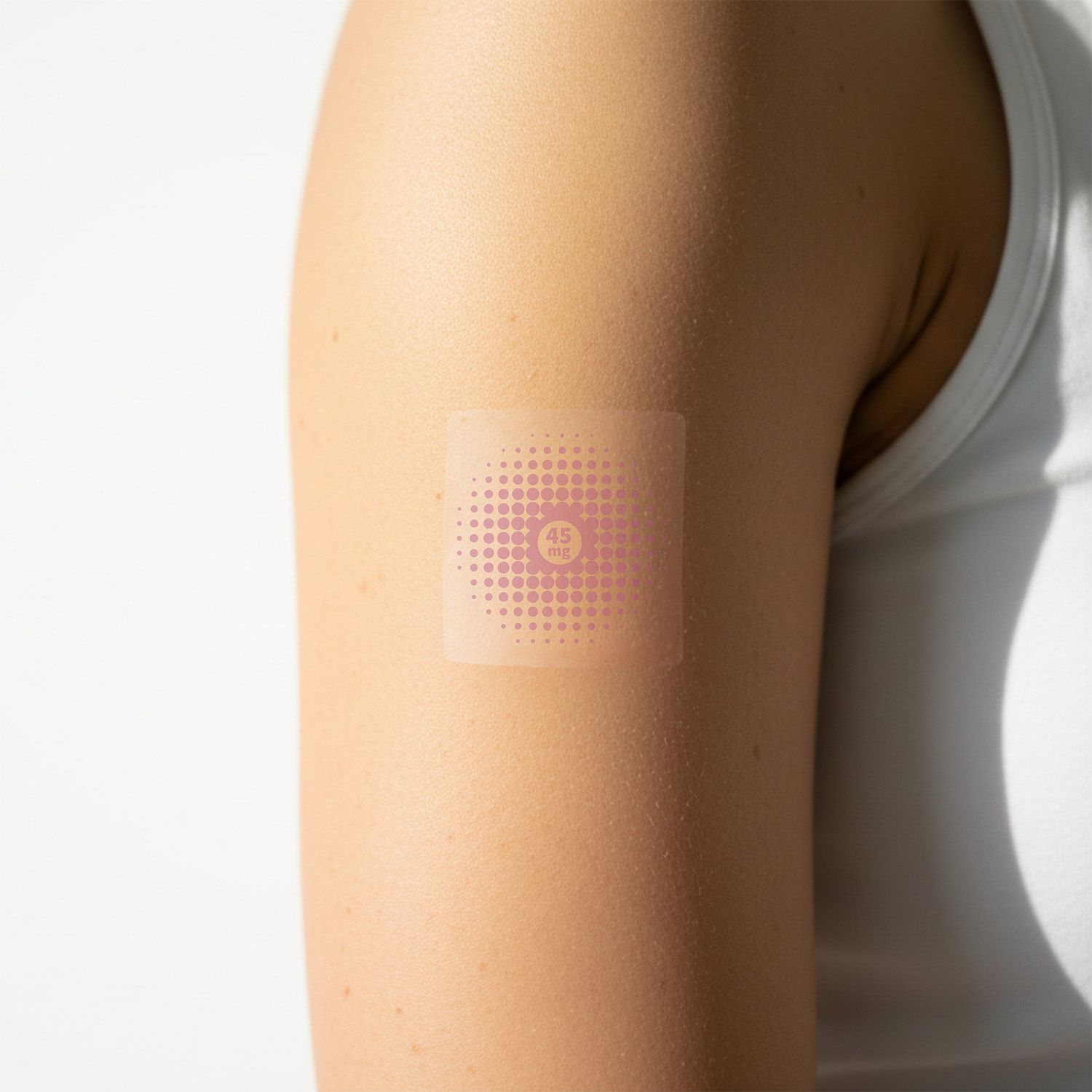 Ein quadratisches Pflaster auf einem Arm. Das Pflaster hat ein rosa Punktmuster und einen rosa Kreis.