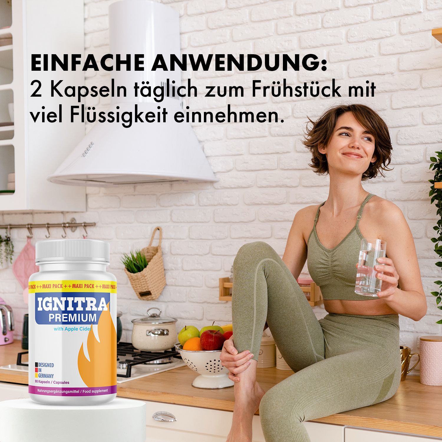 Frau in Sportkleidung sitzt in Küche. Neben ihr steht eine Flasche IGNITRA PREMIUM. Aufschrift: 2 Kapseln täglich mit Flüssigkeit.