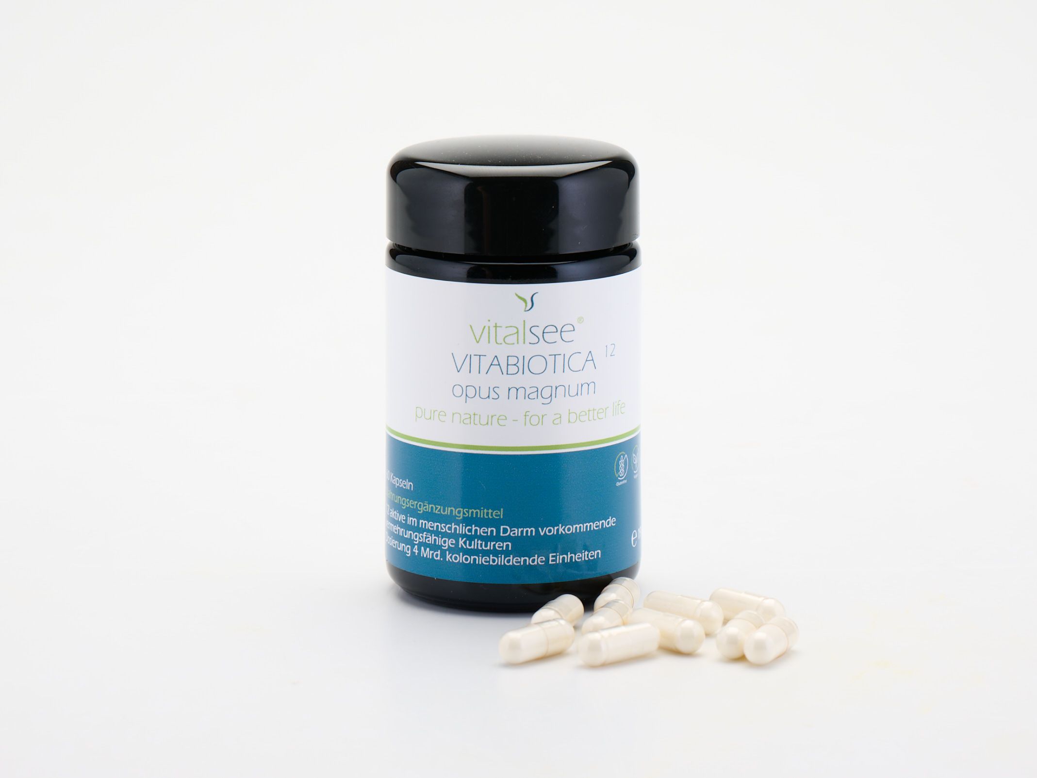 Schwarze Dose mit Kapseln daneben. Aufschrift: Vitalsee VITABIOTICA 12 opus magnum. Blaue und grüne Akzente.