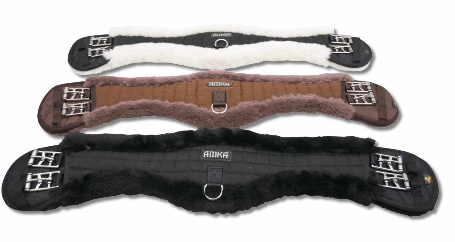 Drei AMKA Dressurgurte in Weiß, Braun und Schwarz. Anatomische Form mit synthetischem Fell und Schnallen.