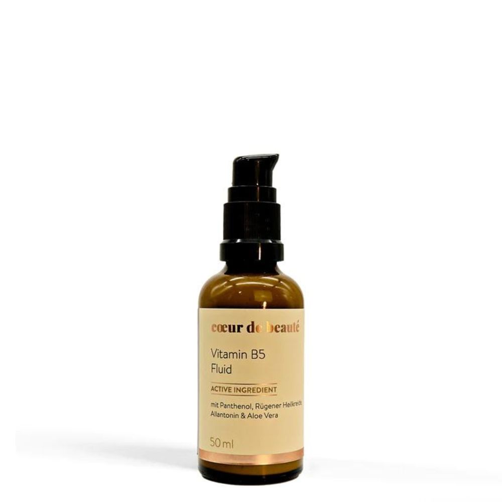 Braune Glasflasche mit schwarzem Pumpkopf. Aufschrift: Coeur de Beauté, Vitamin B5 Fluid, 50ml. Enthält Panthenol, Rügener Heilerde, Allantoin & Aloe Vera.