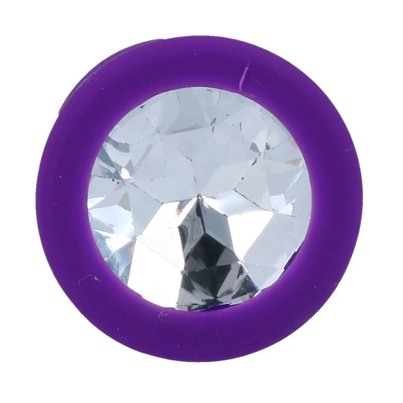 Nahaufnahme eines lila Analplugs mit Kristall. Der Plug hat eine runde Basis mit einem Kristall.