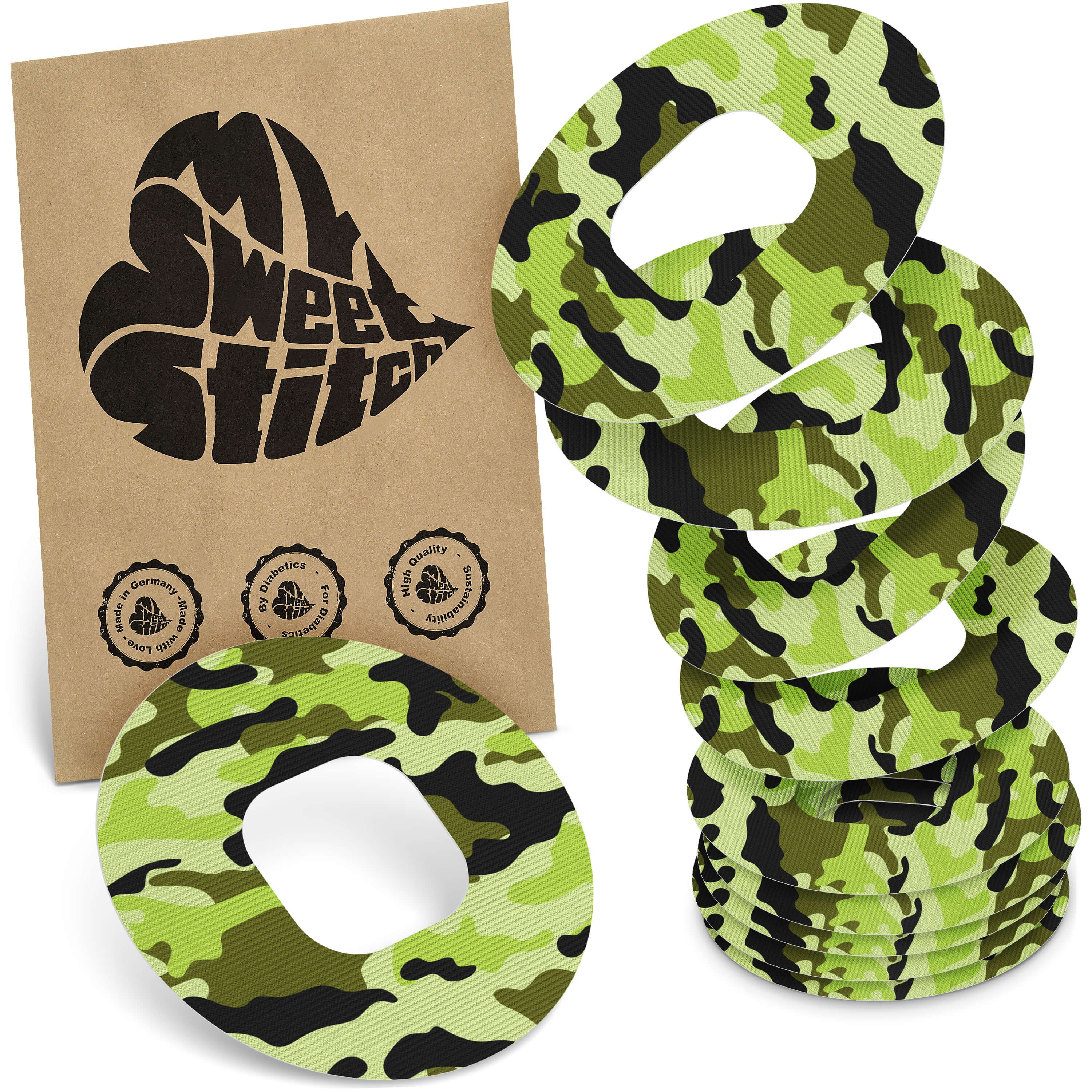 Mehrere runde Pflaster mit Camouflage-Muster. Neben einer braunen Verpackung mit Logo und Qualitätssiegeln.