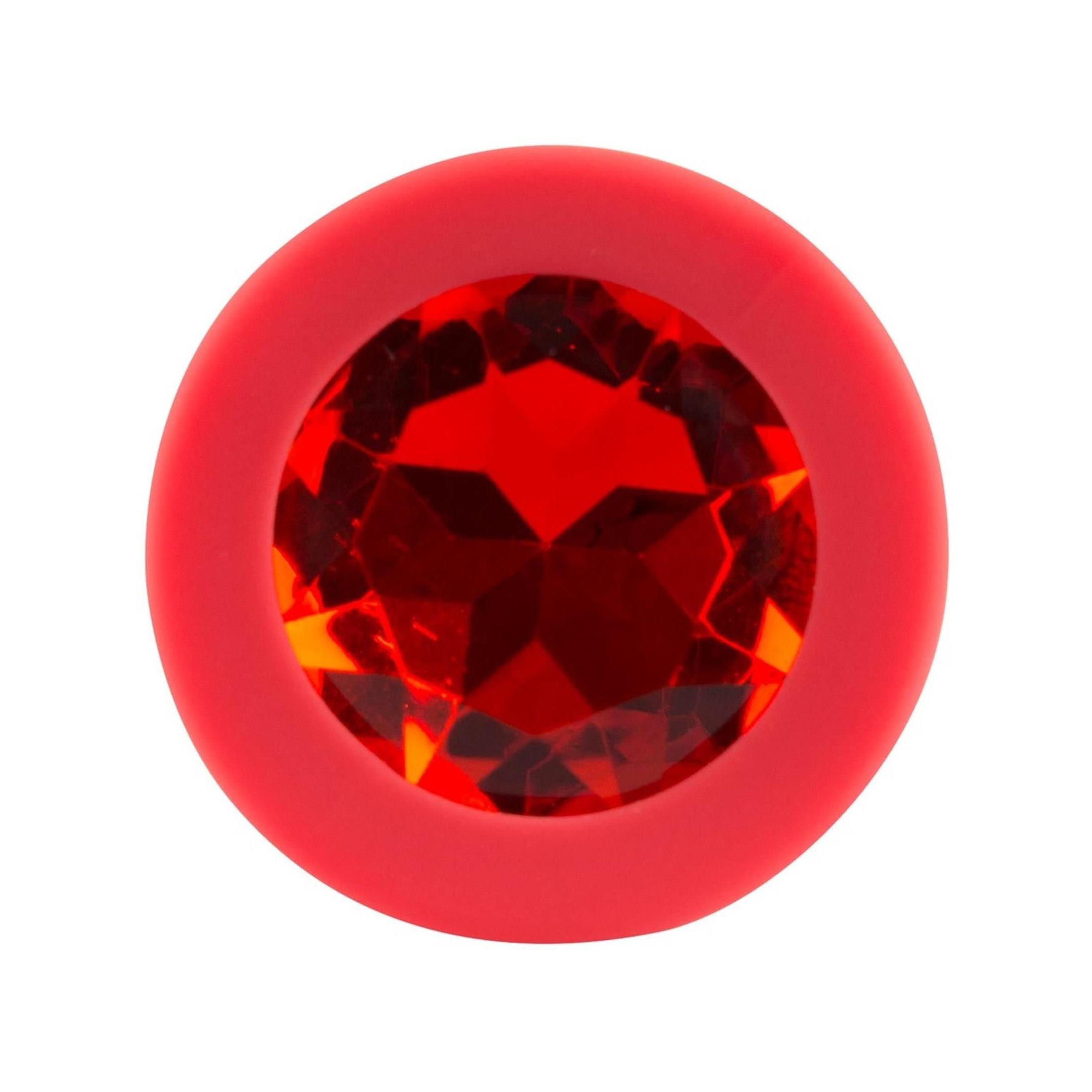 Roter Plug mit rotem Schmuckstein. Runder Sockel mit Schmuckstein. Draufsicht.