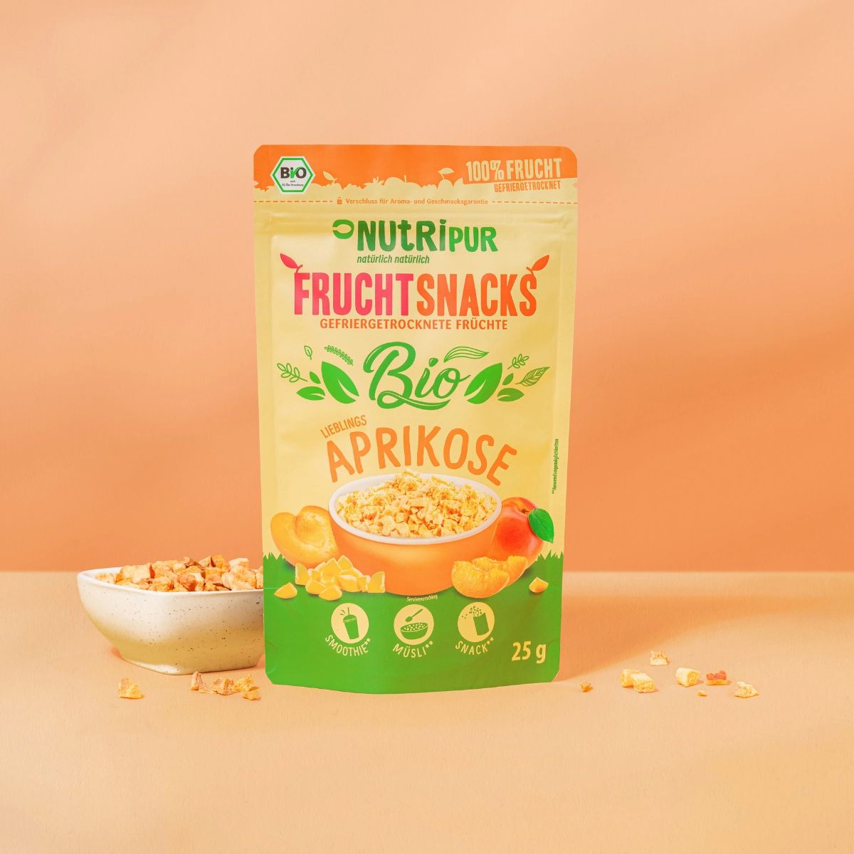 Verpackung NutriPur Fruchtsnacks Bio-Aprikose. Grün-gelbe Tüte mit Logo, Text und Aprikosen-Illustration. 25g.
