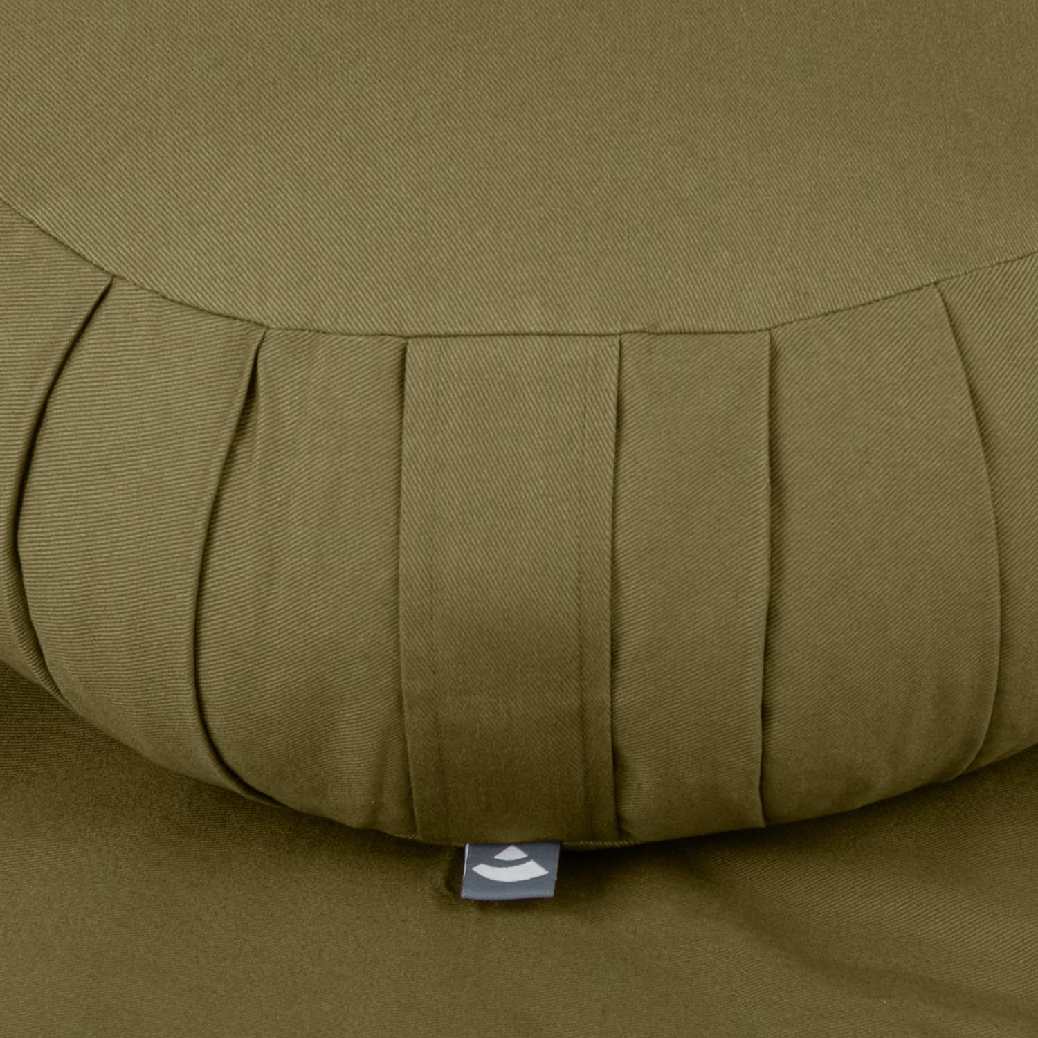 Detailansicht des Zafu-Kissens. Olivgrüner Stoff mit Falten. Kleines Label.