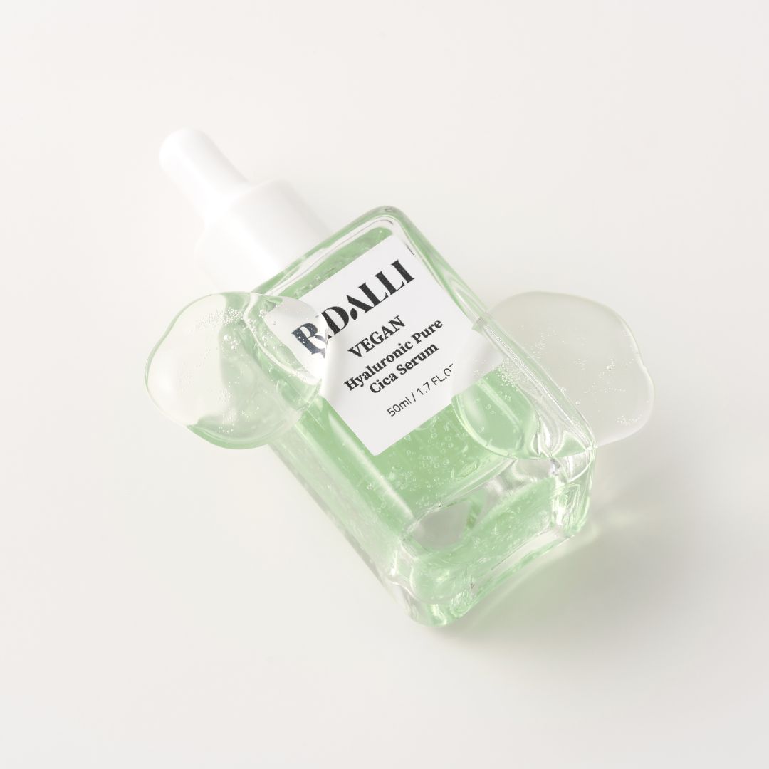 Glasflasche mit grünlicher Flüssigkeit und Pipette. Etikett mit 'Bidalli Vegan Hyaluronic Pure Cica Serum'.