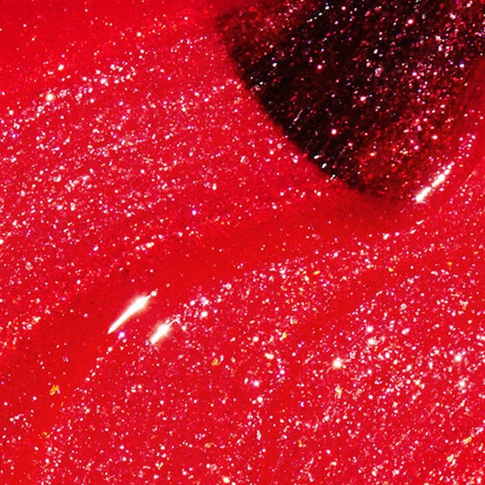 Roter Nagellack mit Glitzer. Der Pinsel ist teilweise sichtbar.