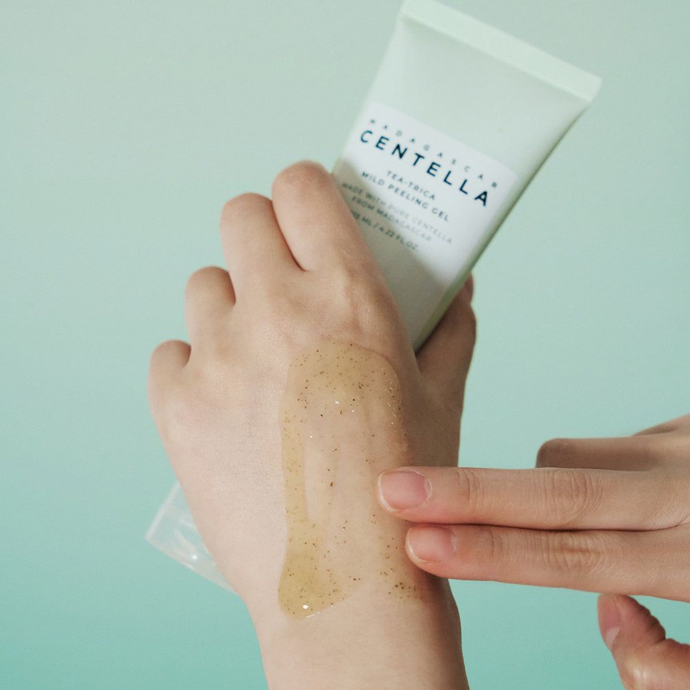 Hand mit Produkt. Aufschrift: MADAGASCAR CENTELLA, Tea-Trica Mild Peeling Gel. Gel auf Hand aufgetragen.