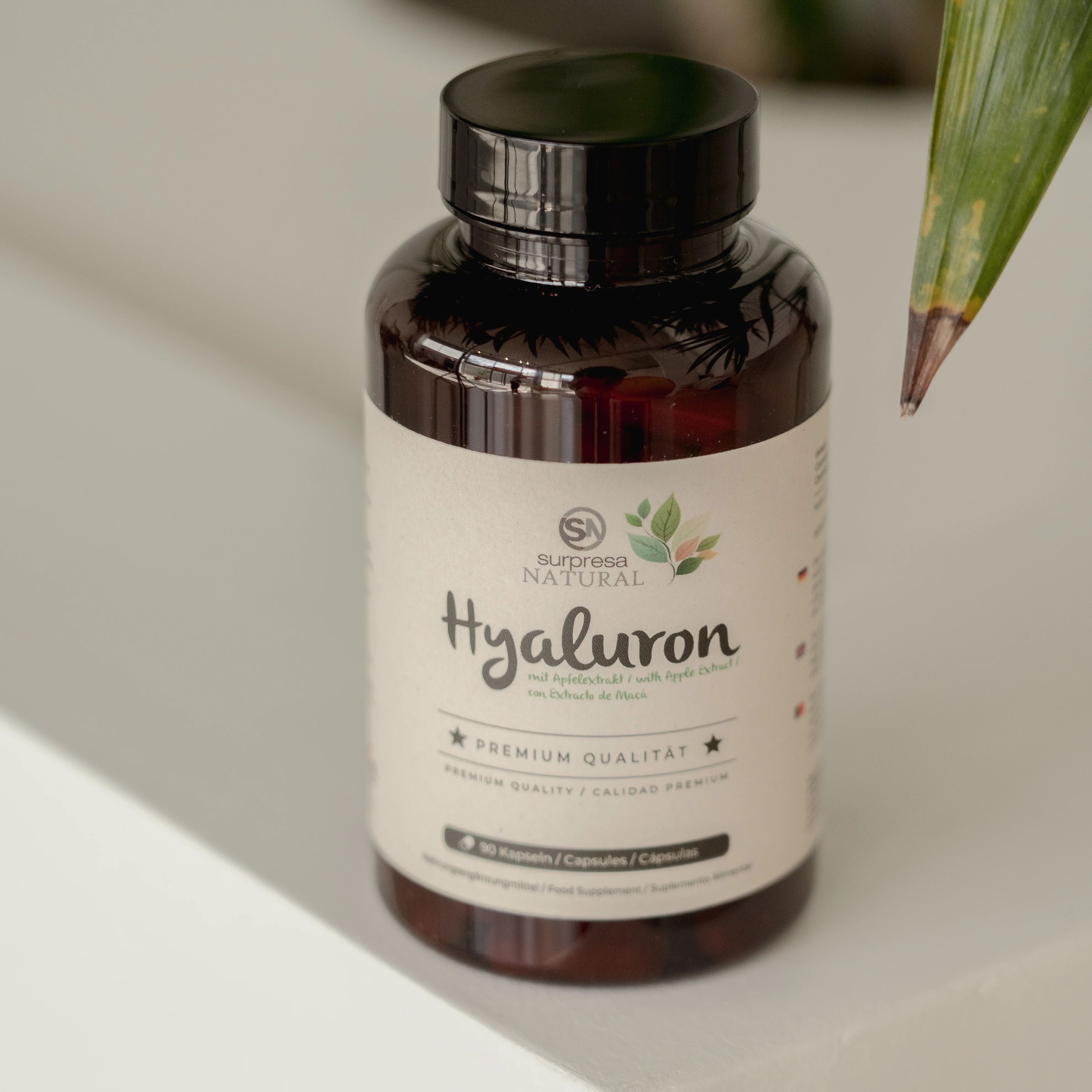 Braune Flasche mit weißen Kapseln. Aufschrift: Surpresa Natural Hyaluron. Premium Qualität. 90 Kapseln.