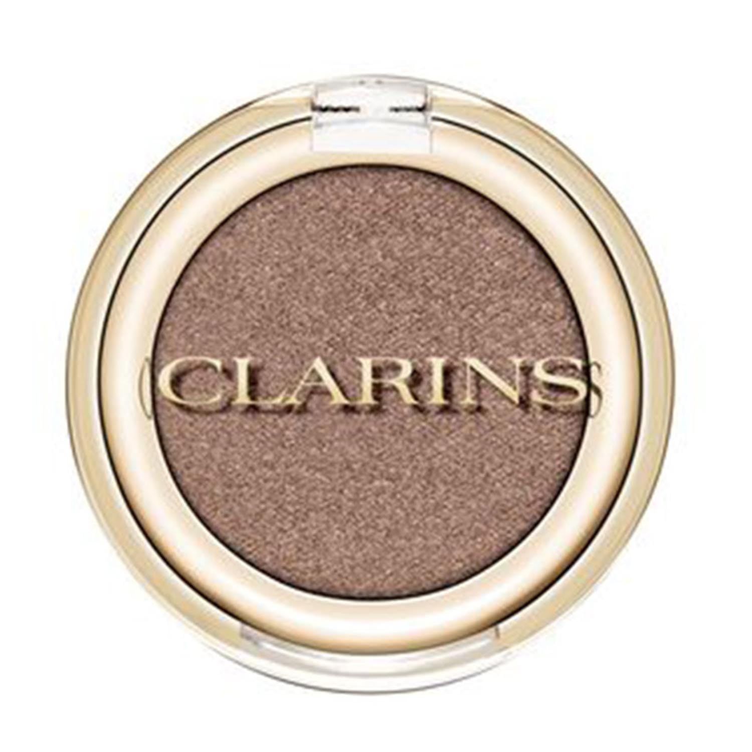 Runder Lidschatten-Compact mit goldfarbenem Rand und transparentem Deckel. Der Lidschatten ist taupefarben. Clarins-Logo.