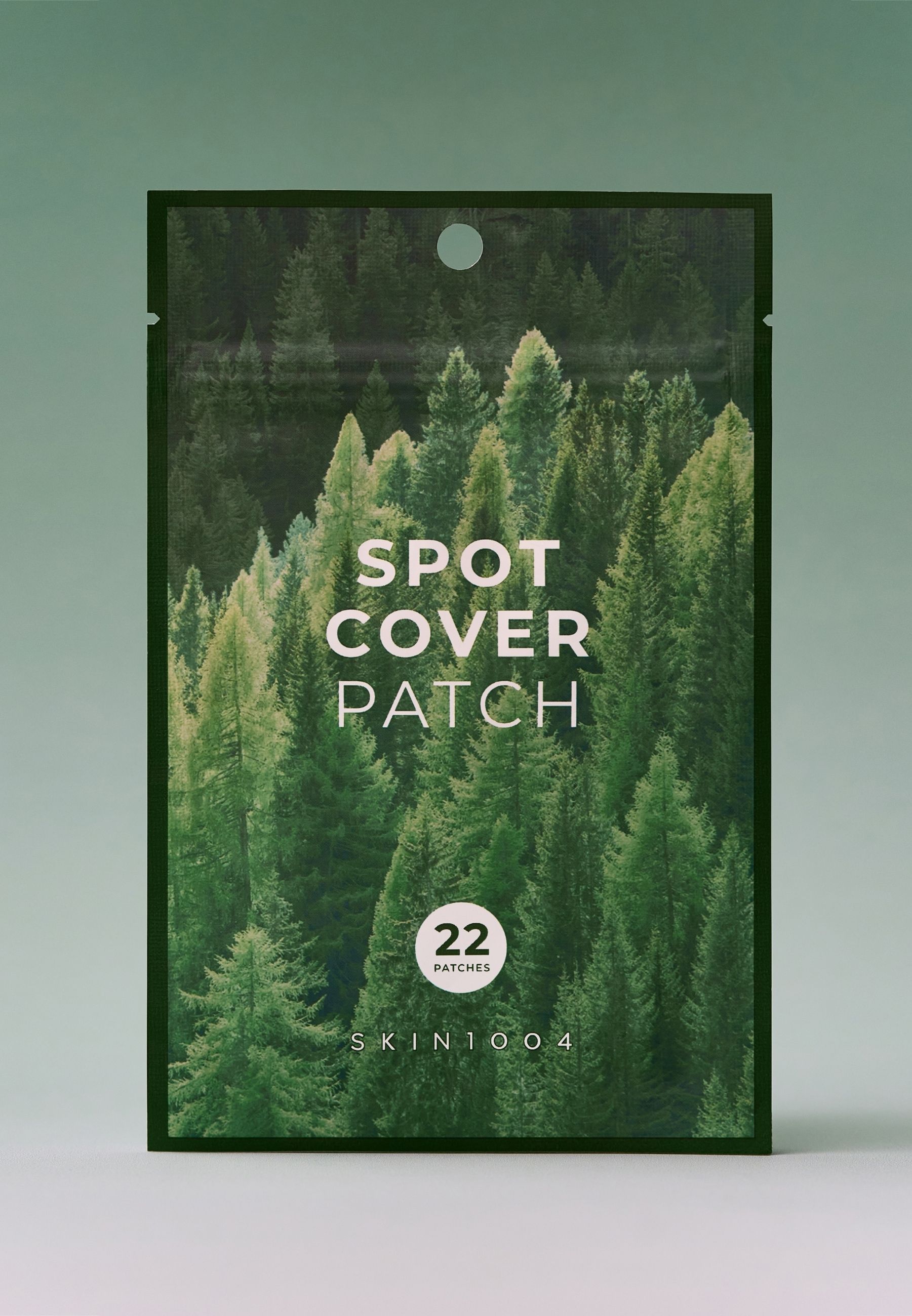 Beutel mit Aufdruck „SPOT COVER PATCH“. Enthält 22 Patches. Marke: SKIN1004. Hintergrund: Wald.