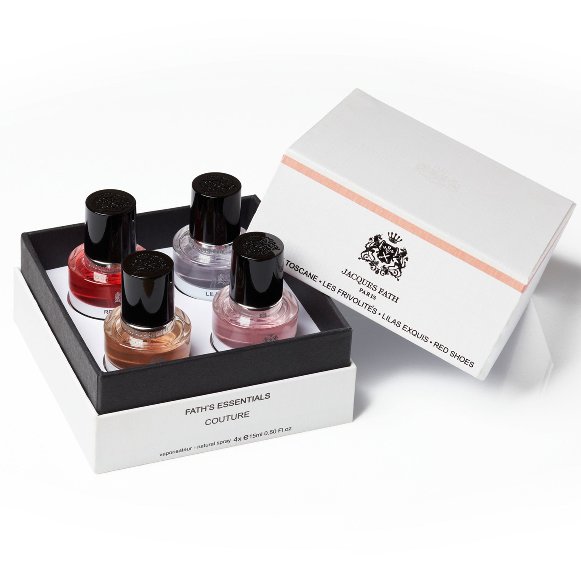 Geschenkbox mit vier Parfumflakons. Schwarze Kappen, farbige Flüssigkeiten. Aufschrift: Fath's Essentials Couture. Geöffnete Box.
