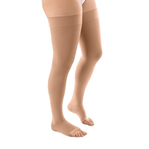 Hautfarbene Kompressions-Schenkelstrümpfe mit offener Fußspitze. Seitliche Ansicht.