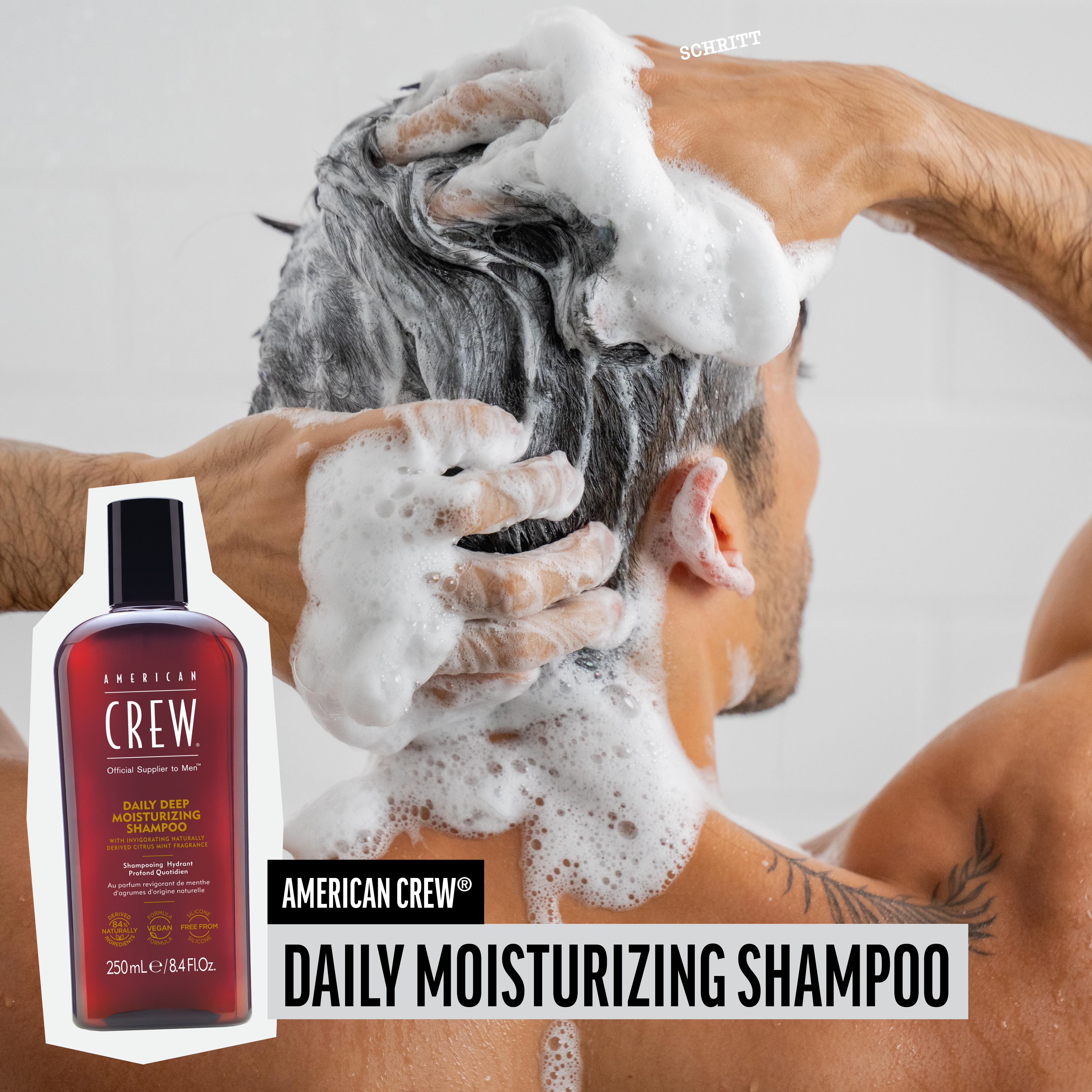 Mann wäscht sich die Haare mit Shampoo. AMERICAN CREW Daily Moisturizing Shampoo-Flasche im Bild. 250ml/8.4 fl.oz.