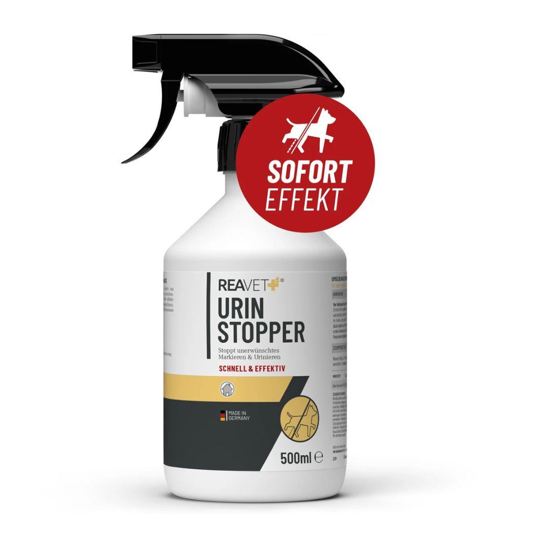 Weißes Sprühflasche mit schwarzem Sprühkopf. Roter Aufkleber mit Hund. Text: Urin Stopper, Schnell & Effektiv, 500ml.