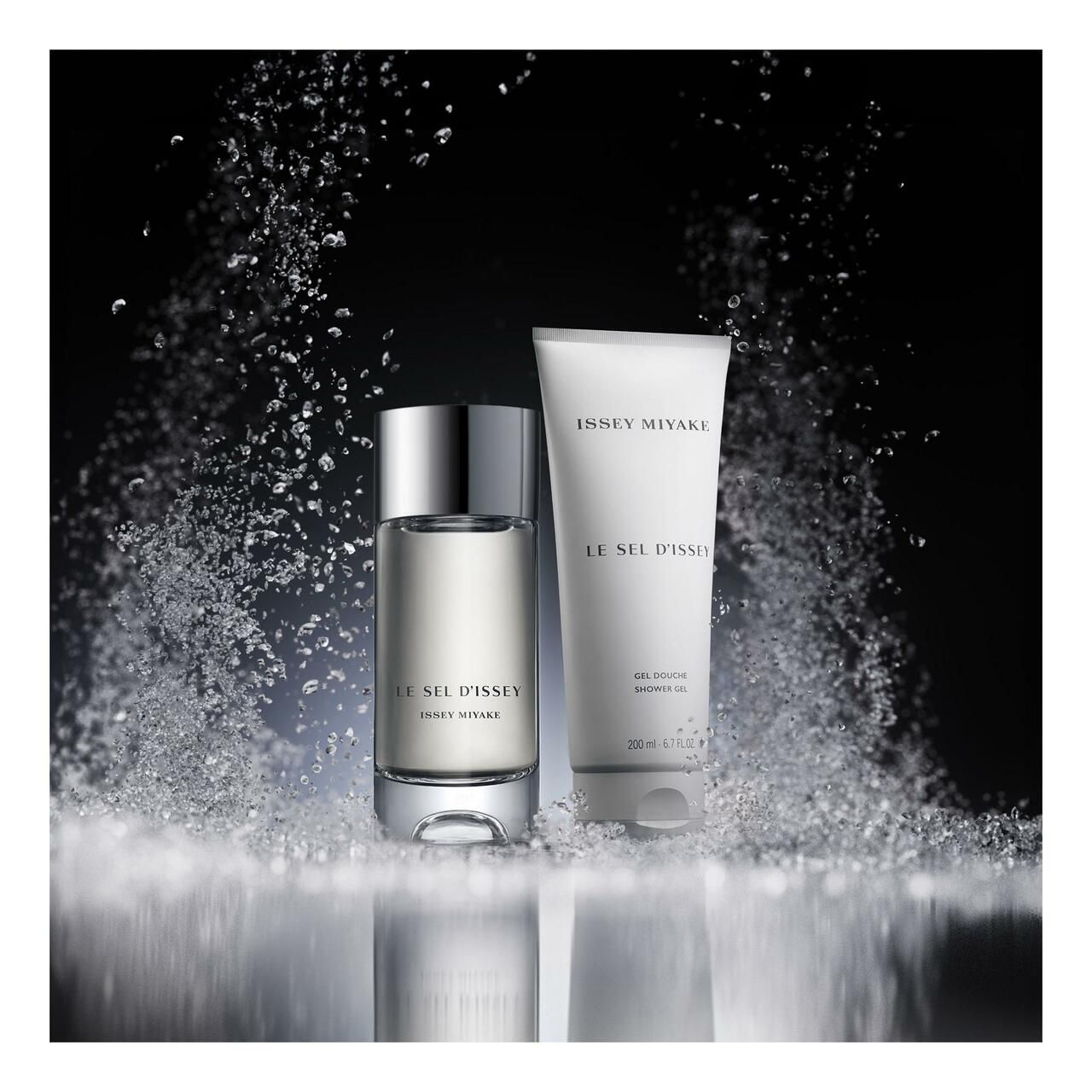 Zwei Produkte auf einer Oberfläche mit Wasserspritzern. Eine Flasche und eine Tube. Produktname und Marke sind sichtbar.