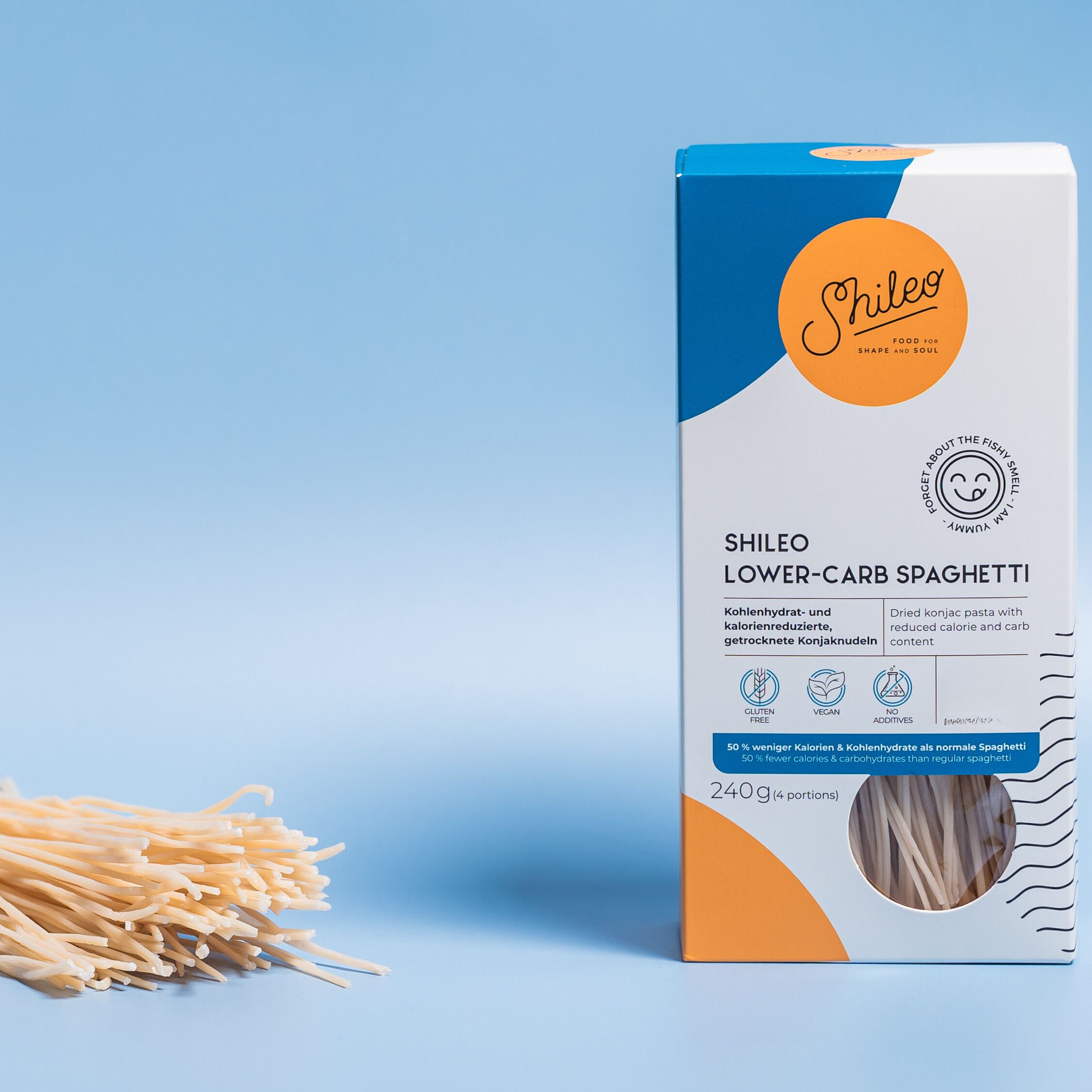 Verpackung SHILEO Lower-Carb Spaghetti. Daneben Spaghetti. Aufdrucke: Logo, Produktname, Nährwertangaben, Zertifizierungen. Blauer Hintergrund.