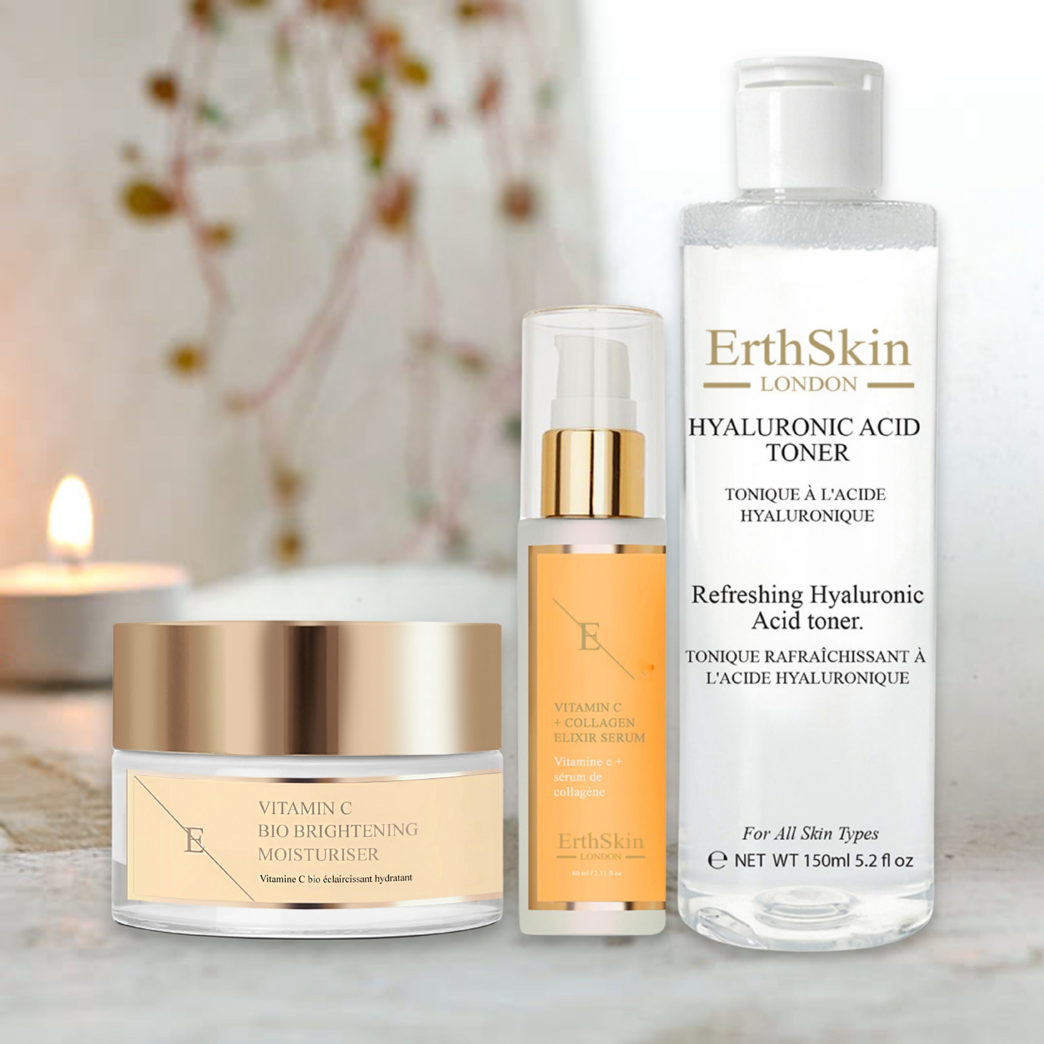 Set aus Creme, Serum und Toner. Creme- und Serumbehälter mit goldfarbenen Deckeln. Tonerflasche mit weißem Deckel. Beschriftung: ErthSkin London, Vitamin C.