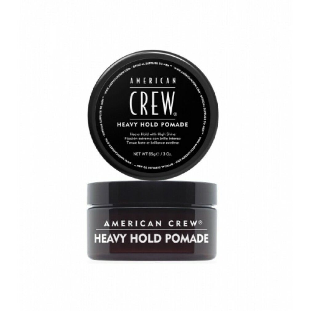 Schwarze Dose mit Deckel. Aufschrift: AMERICAN CREW, HEAVY HOLD POMADE. Runde Form, Produktname deutlich sichtbar.