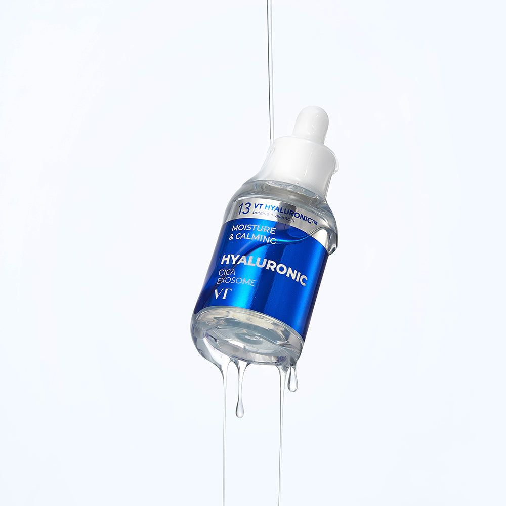 Klarflüssiges Serum in einer Flasche mit blauem Etikett. Tropfen fallen. Text: Hyaluronic Cica Exosome, VT.
